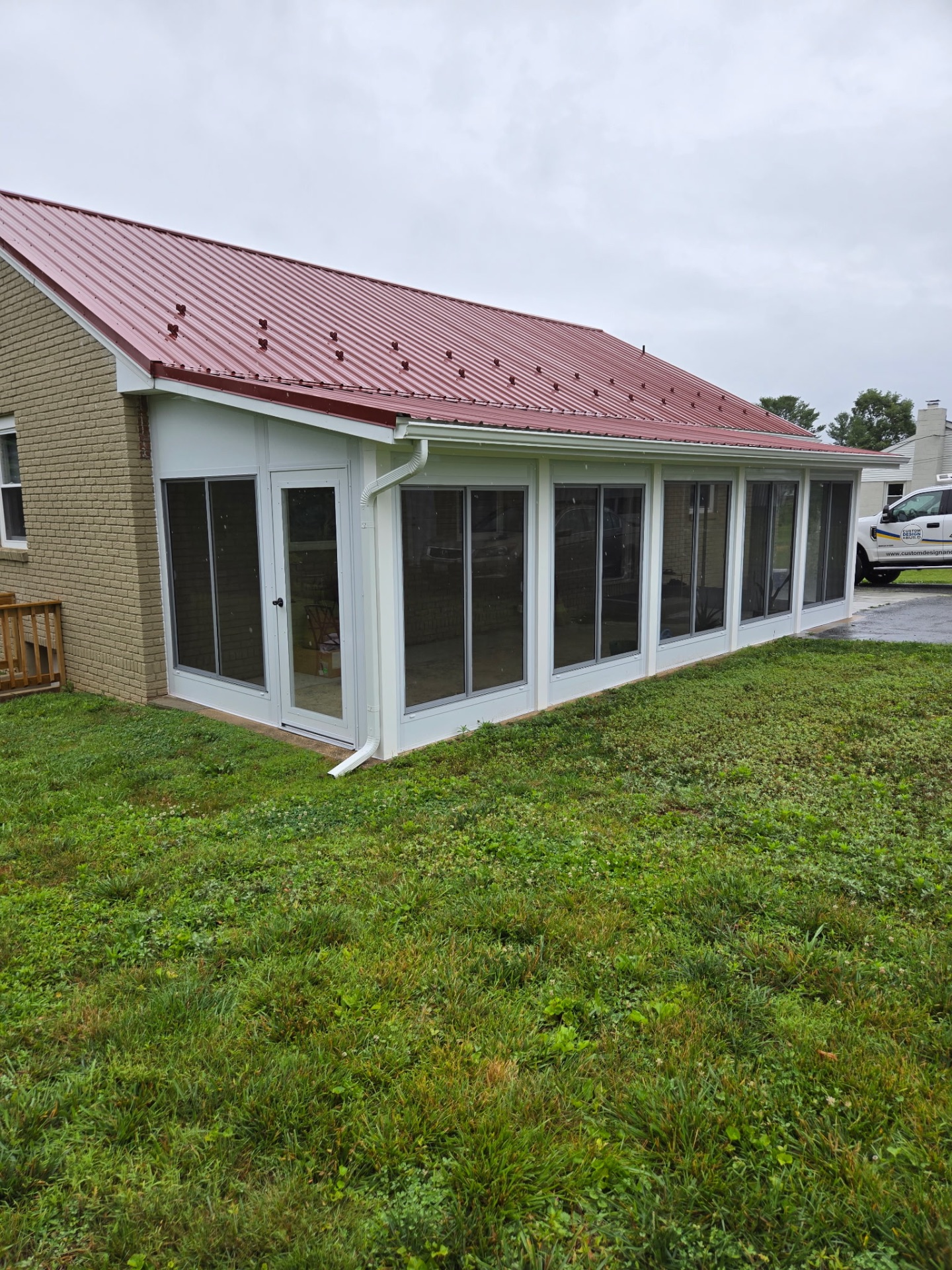 Side angle of a Custom Design & Build Sunspace porch conversion with hinged entry door and sliding window panels