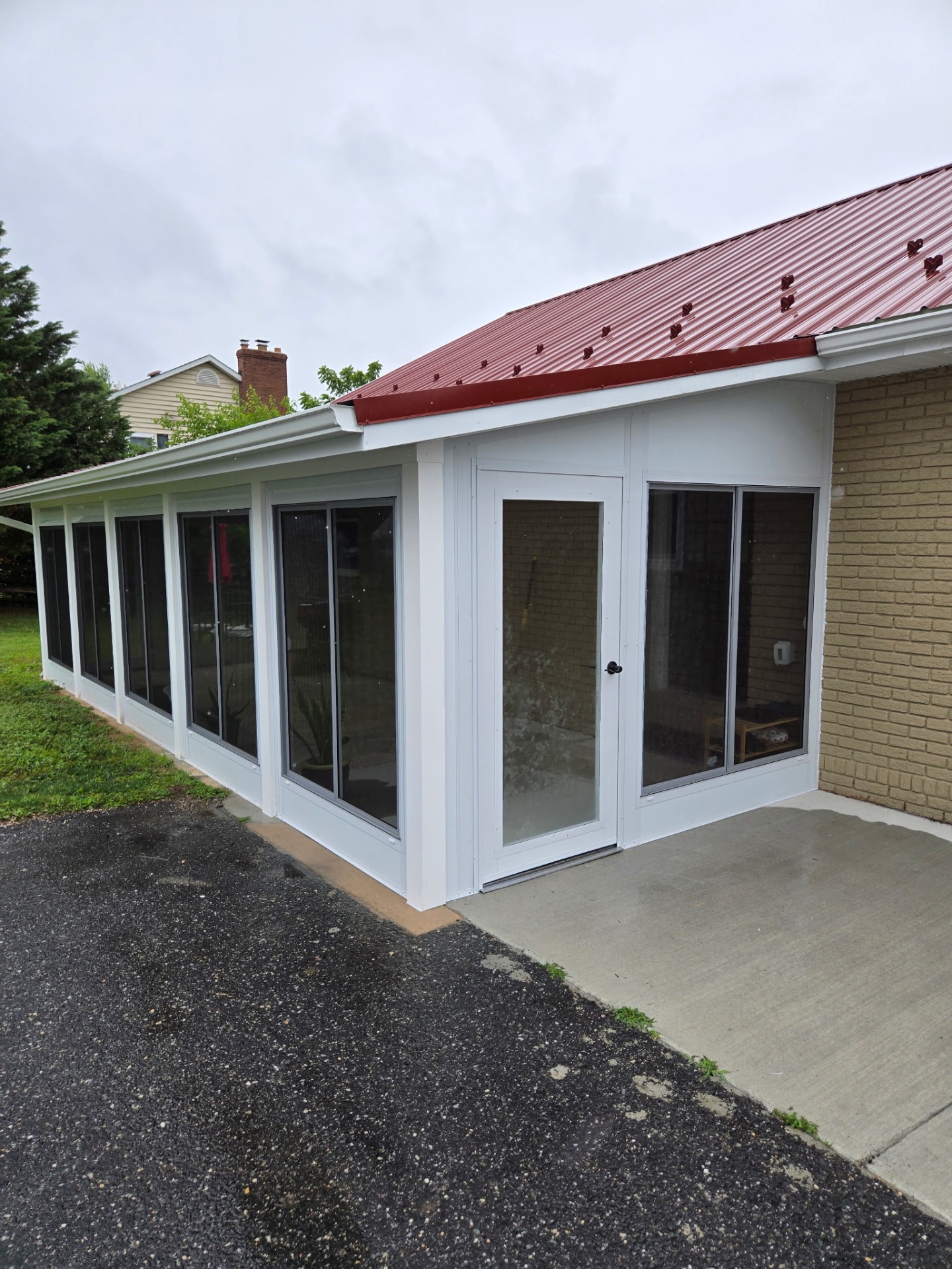 WeatherMaster porch conversion close-up showing the hinged door, sliding windows, and clean white frame detail