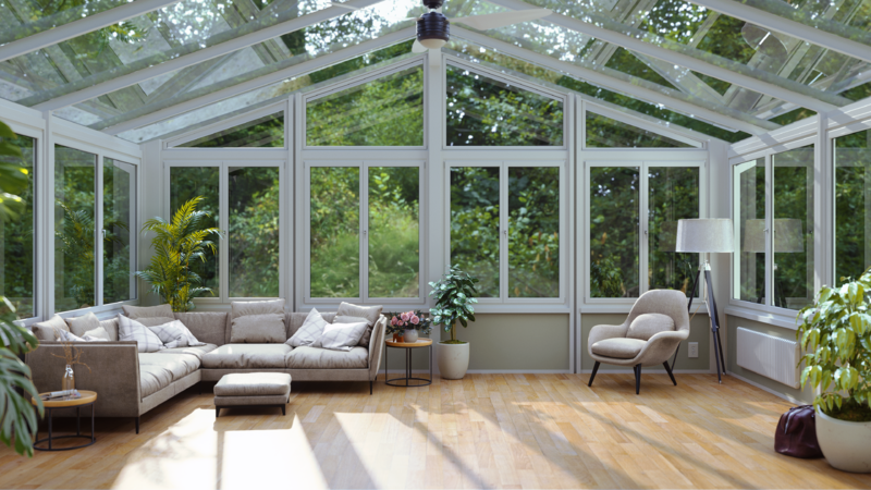 Bright sunroom with plants and comfortable seating.